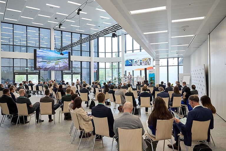 Personen sitzen im Konferenzsaal bei einem Vortrag