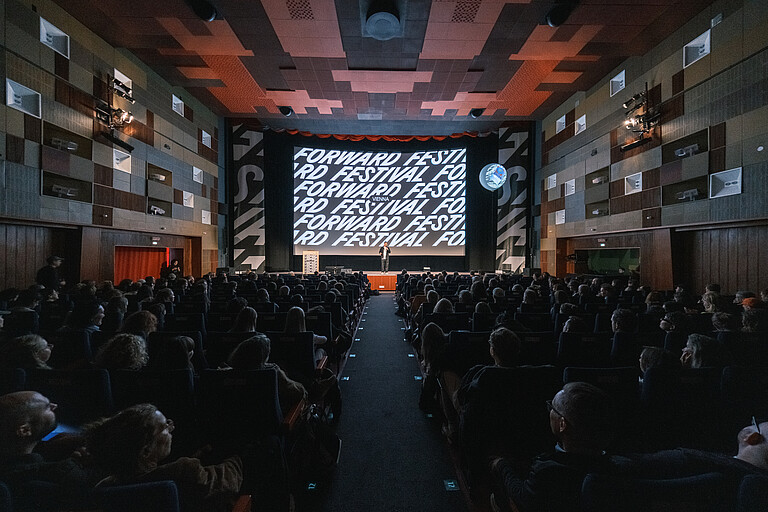 Leinwand des Gartenbau Kino mit Aufschrift Forward Festival und vollem Kinosaal