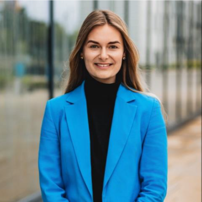 Alexandra Kick NEU Blonde Frau mit blauen Blazer, lächelt in die Kamera.