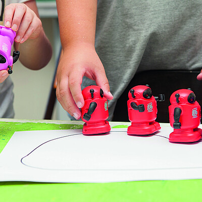 Kinderhände bewegen kleine Roboter .