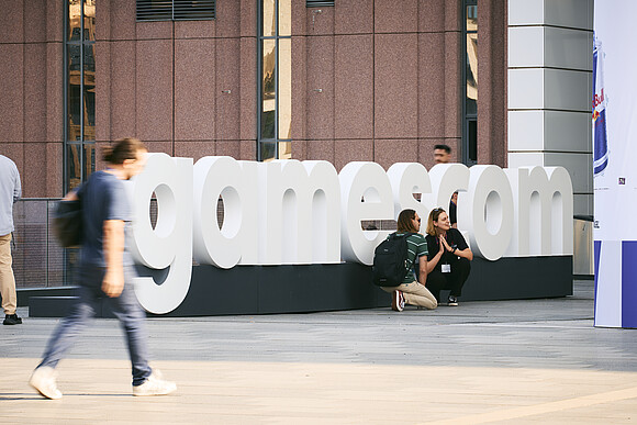 Gamescom Schriftzug mit Besucher*innen