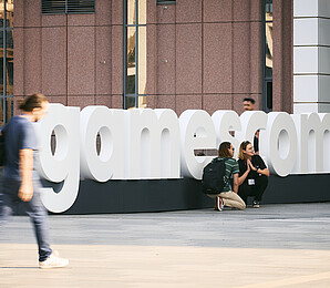Gamescom Schriftzug mit Besucher*innen
