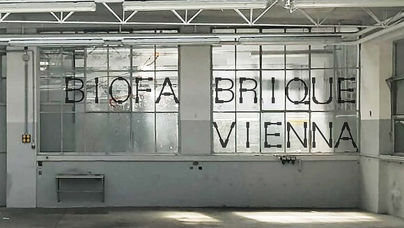 Biofabrique Vienna Logo auf Fenster im Ausstellungsraum platziert