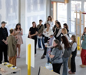 Gruppe an Personen die durch eine Ausstellung geführt werden