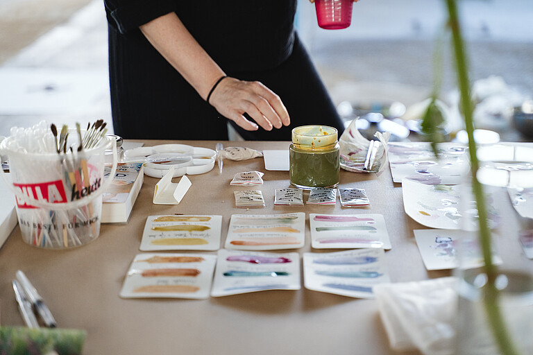 Person experimentiert auf Papier mit "Wiener Farben"