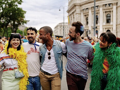 Group of smiling people standing in front of Vienna's Burgtheater