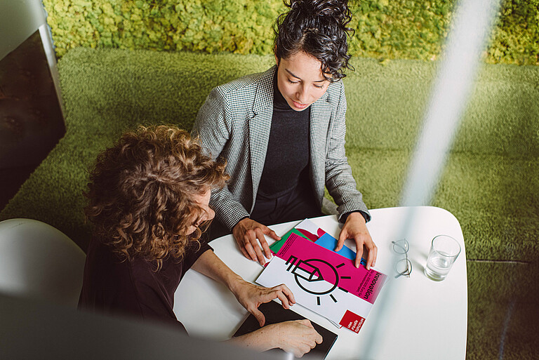 Beratung für Unternehmen, Gründer*innen und Startups in der Wirtschaftsagentur Wien. Zwei Frau sitzen gemeinsam an einem Tisch und unterhalten sich.
